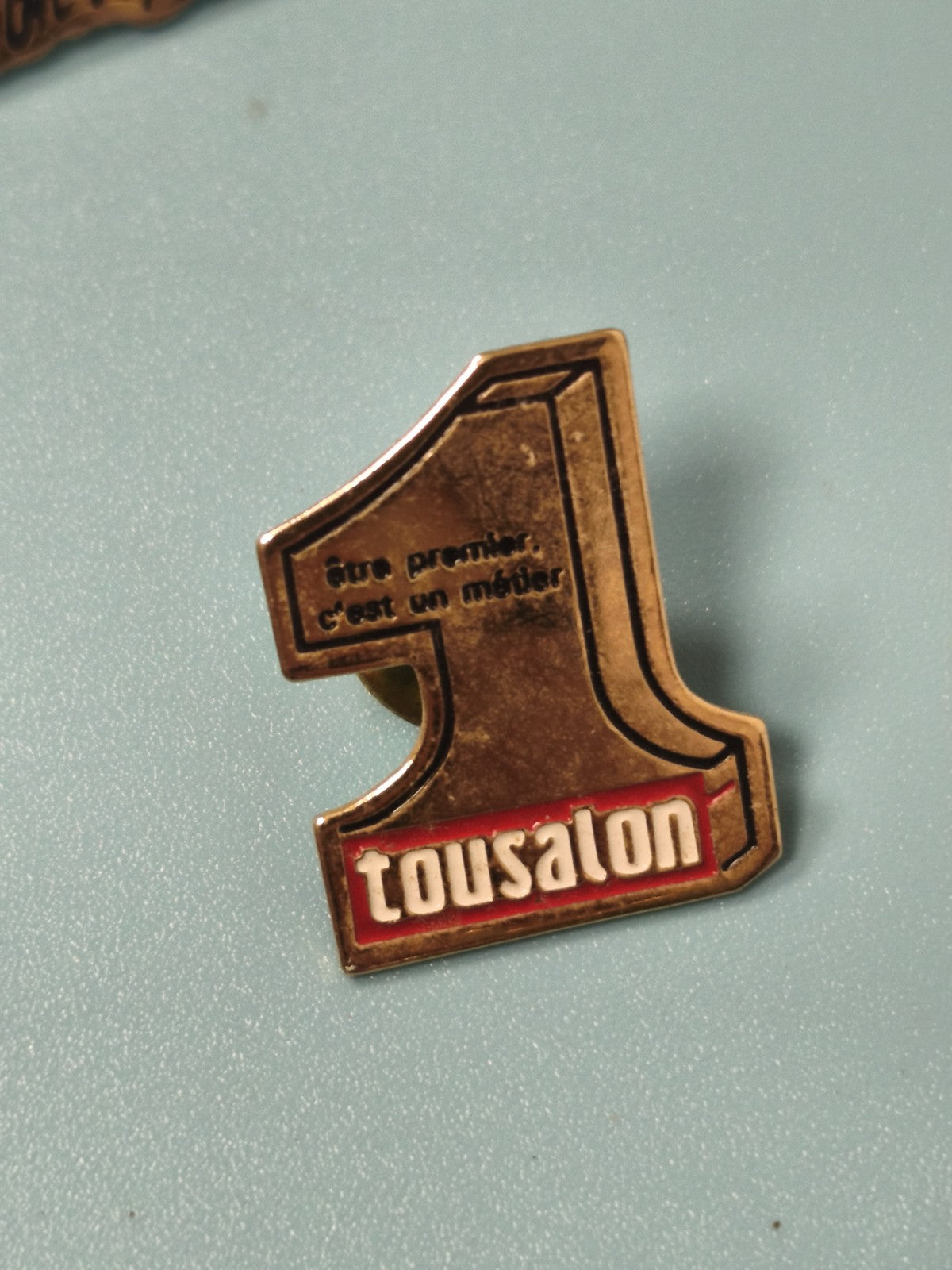 Vintage pin's Tousalon numéro 1 doré, slogan "Être premier", collection déco
