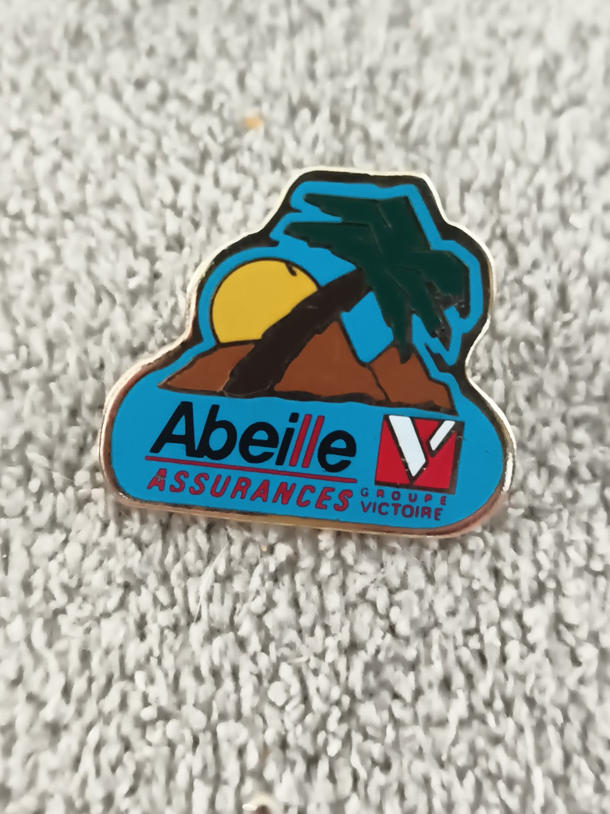 Pin's vintage Abeille Assurances Groupe Victoire logo palme soleil années 90