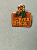 Pin's vintage Justin Bridou publicitaire, fond orange, personnage illustré, coll