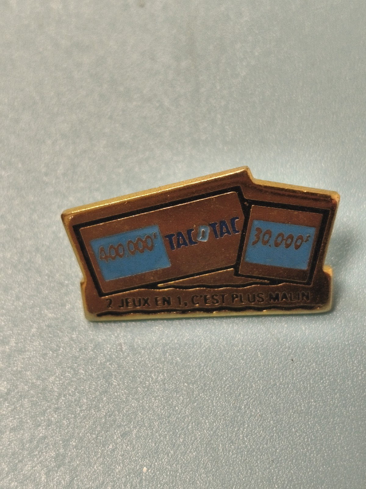 Vintage pin's publicitaire Tacotac jeu de loterie, bleu doré, 2 jeux en 1