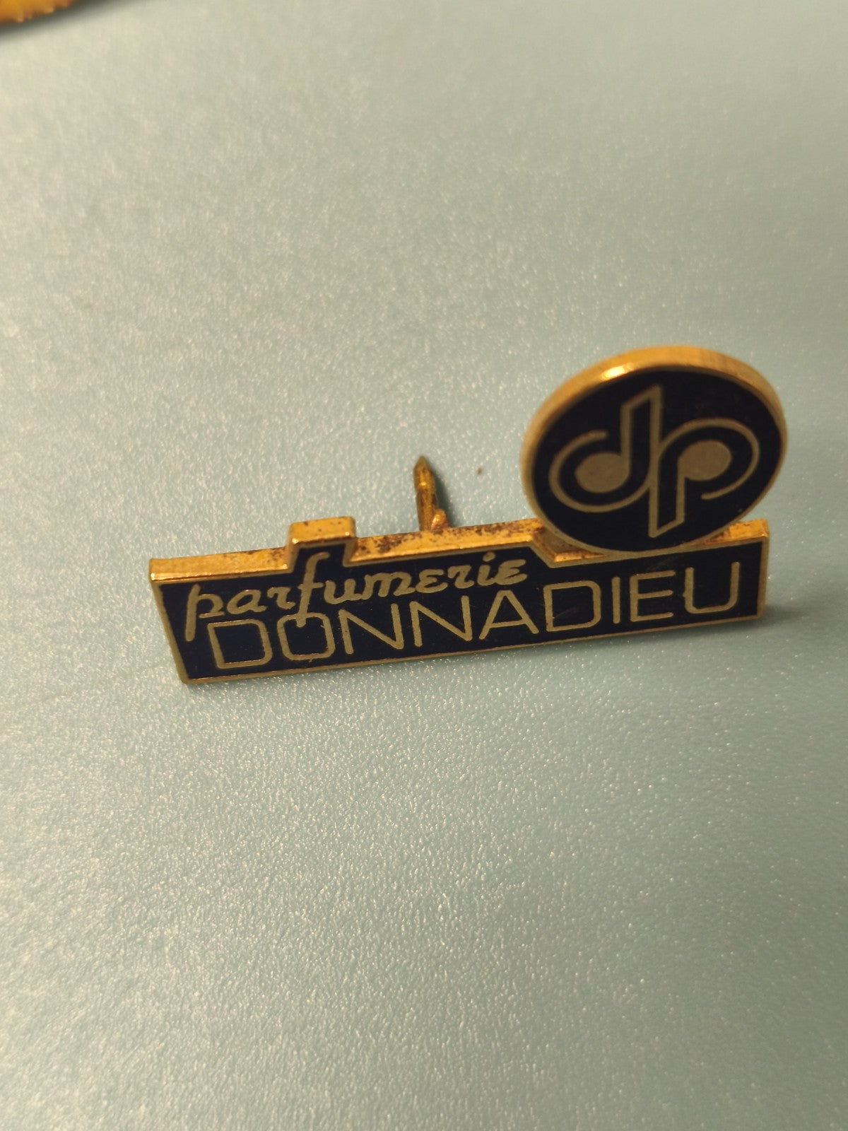 Vintage pin's parfumerie DONNADIEU bleu doré logo dp collection parfum