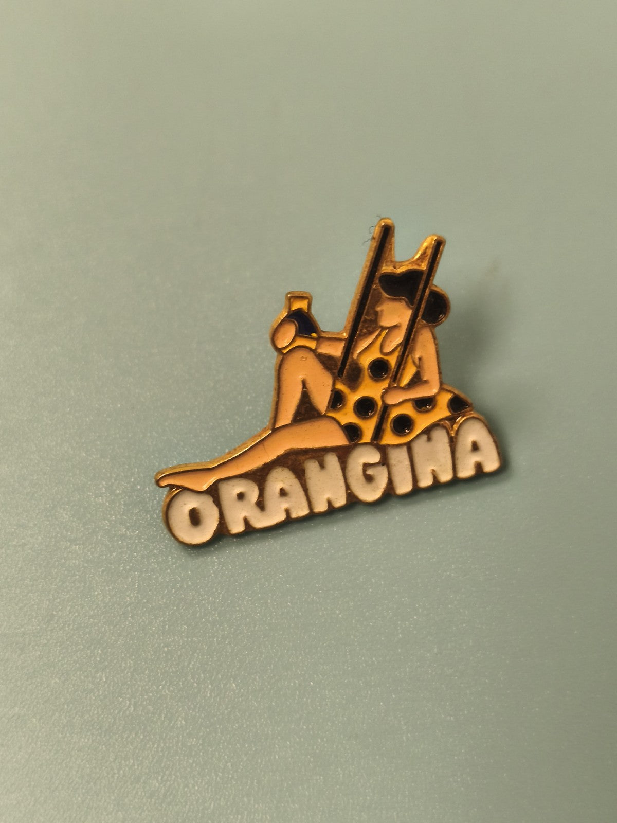 Pin's vintage Orangina publicitaire, personnage assis, collection badge ancien
