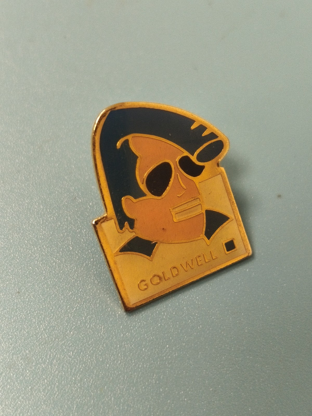 Pin's vintage Goldwell, émail doré, personnage stylisé, collection rétro