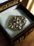 Broche vintage en métal argenté motif floral ajouré rétro