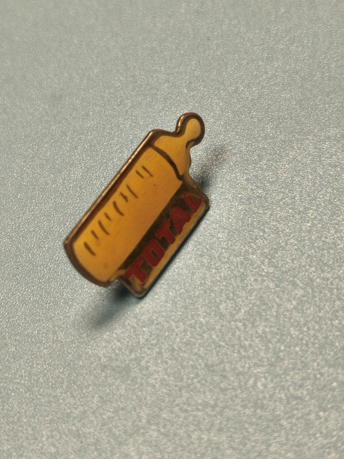 Pin's vintage TOTAL biberon jaune, collection publicitaire ancien ref 10