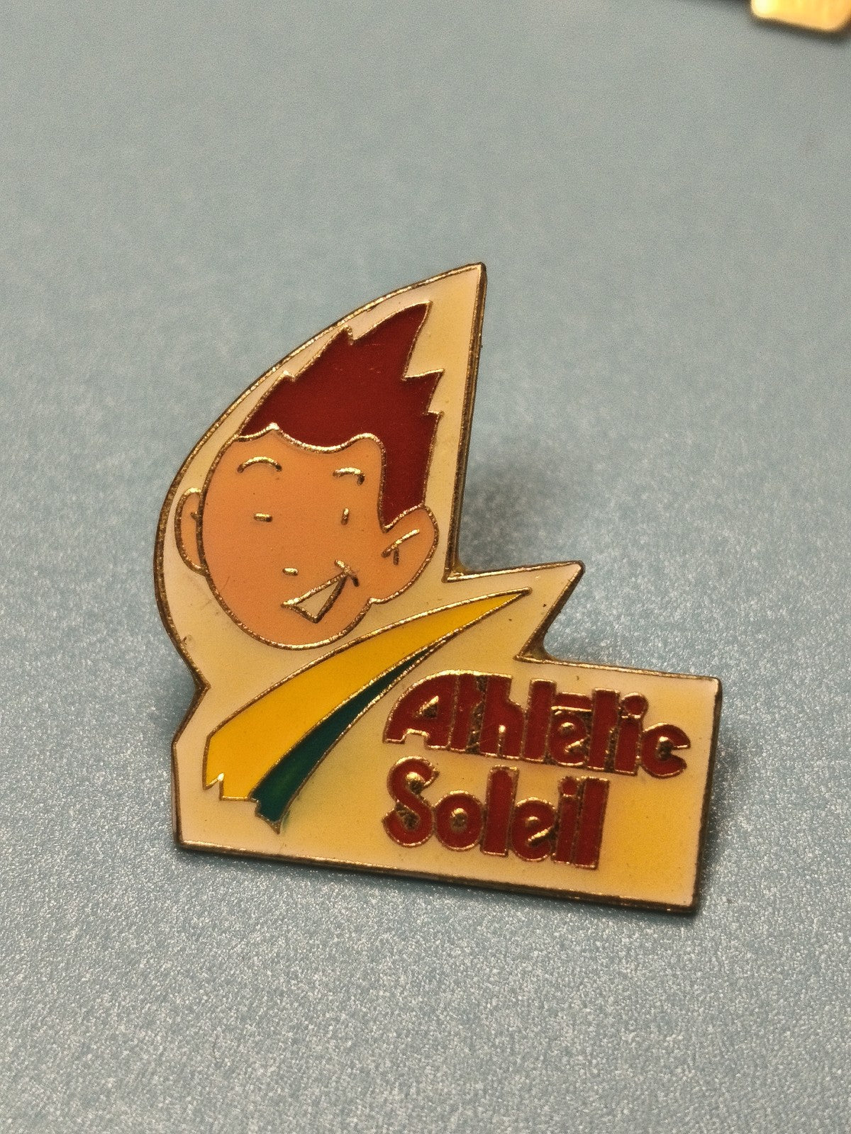 Vintage pin's Athletic Soleil émaillé, personnage cartoon jaune et rouge