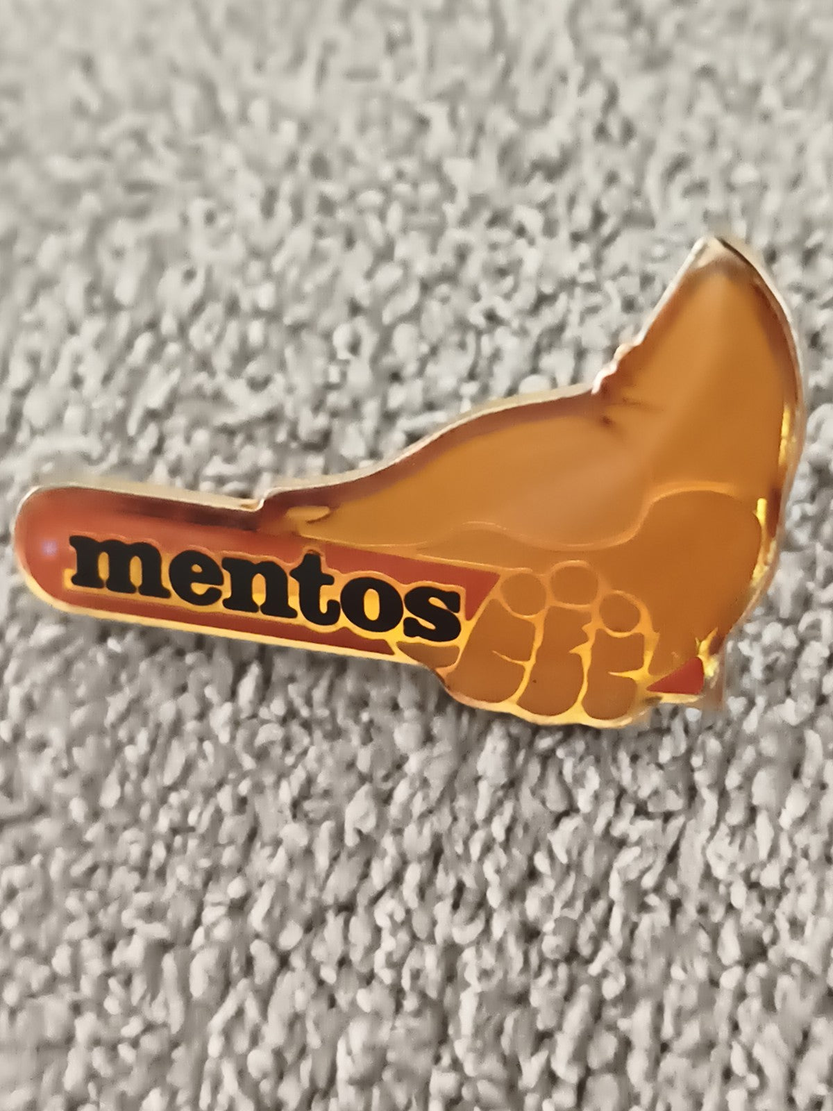 Pin's publicitaire vintage Mentos main orange rétro badge ancien (Ref 6)