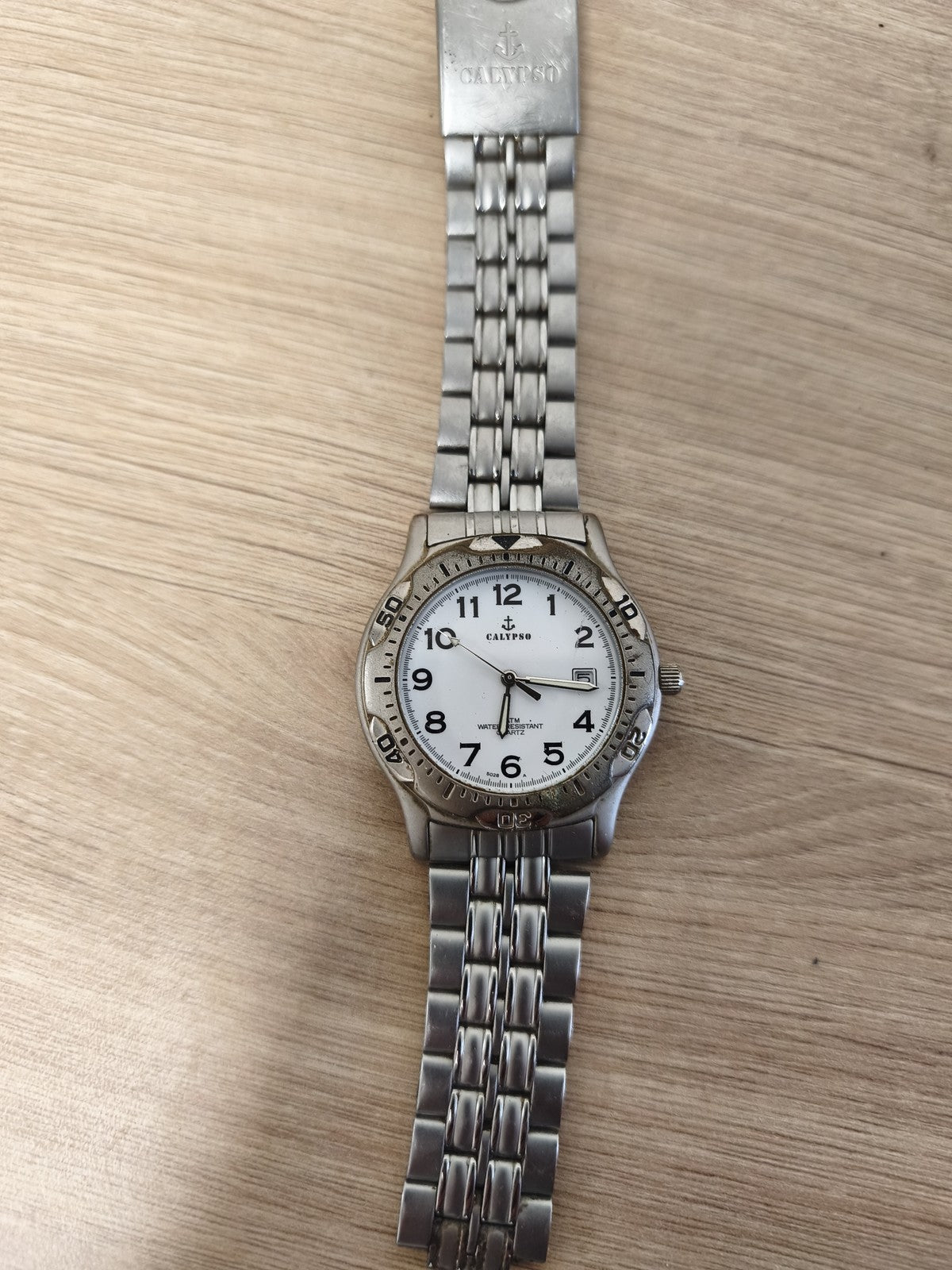 Montre Calypso homme bracelet métal argenté cadran blanc chiffres noirs étanche