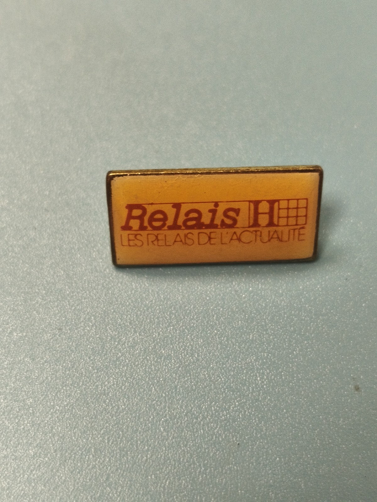 Vintage pin's Relais H rectangulaire jaune Les Relais de l'Actualité