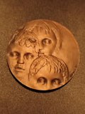Médaille ronde trois visages enfants signée CROCQUE SC aspect bronze relief