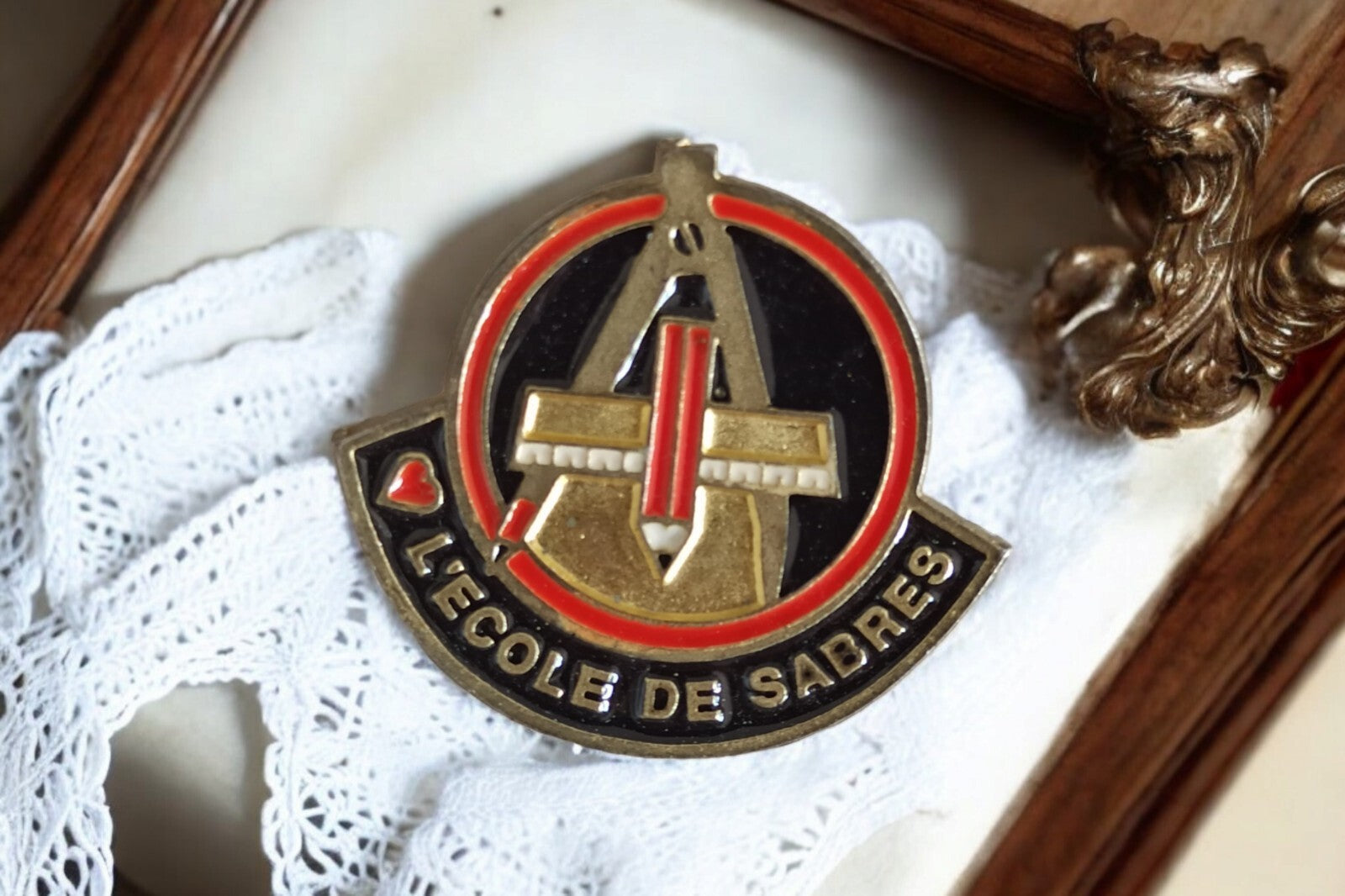 Pin's vintage L'École de Sabres France ? insigne émaillé noir rouge doré