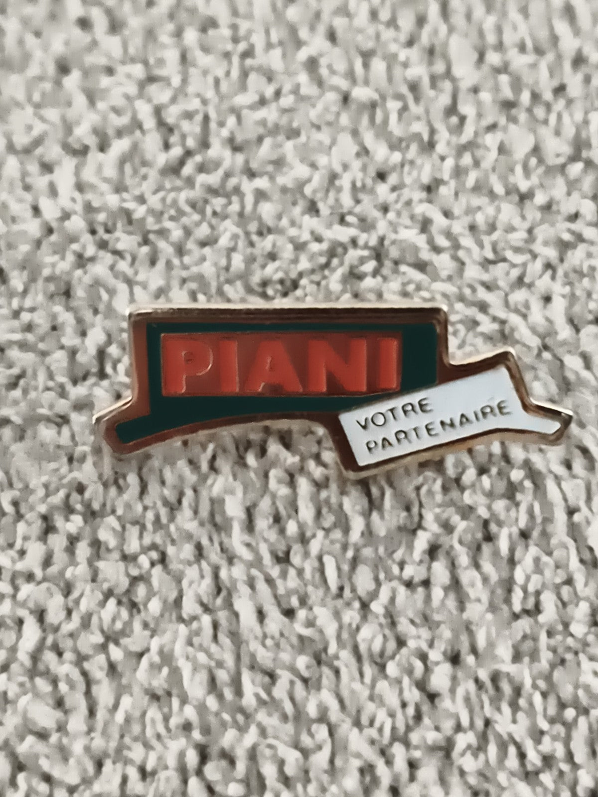 Pin's publicitaire vintage PIANI logo rouge vert, badge ancien "Votre Partenaire