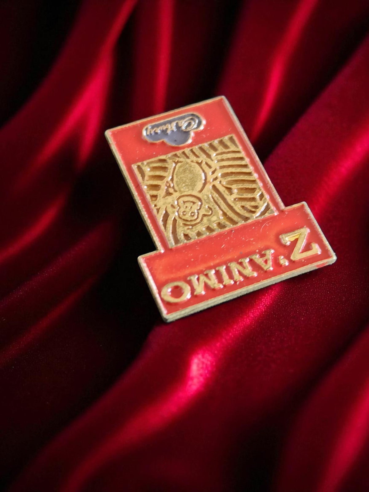Pin's publicitaire vintage Z Animo Cadbury rouge doré rare