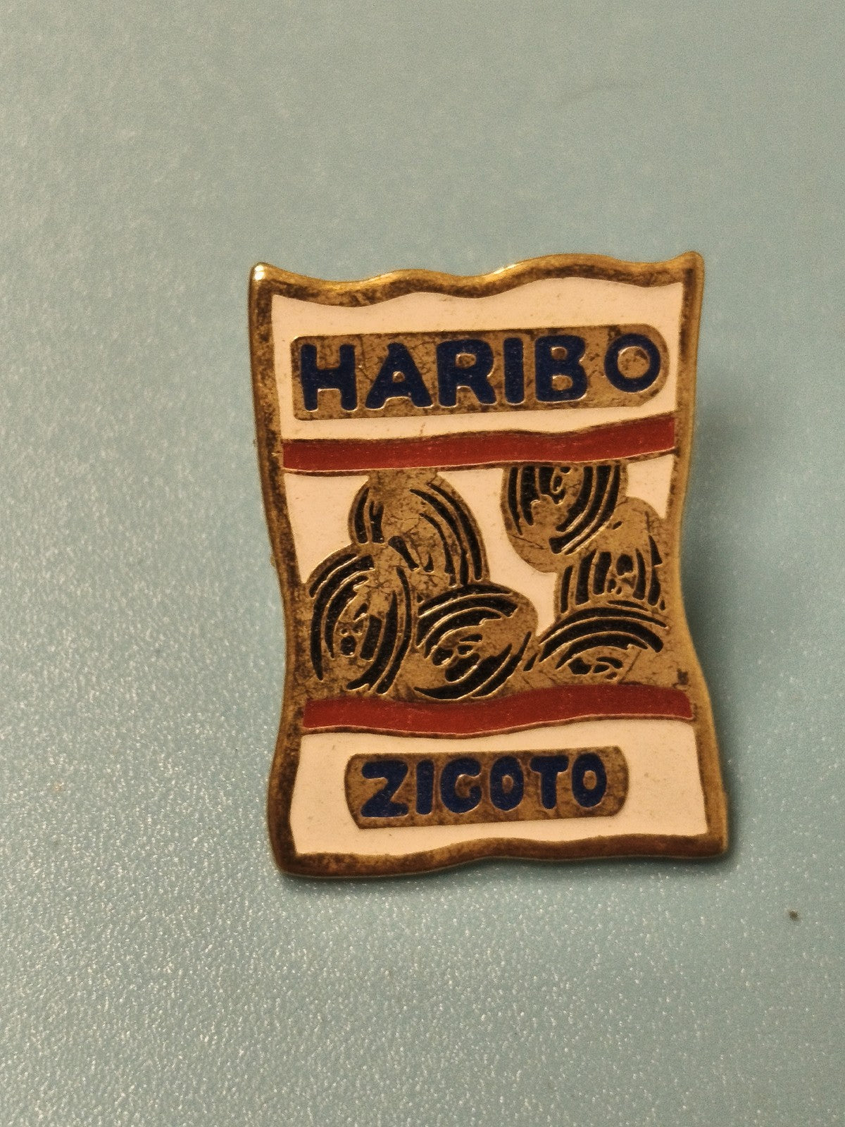 Pin's vintage HARIBO Zigoto ancien, émaillé, forme sachet, collection (Ref 13)