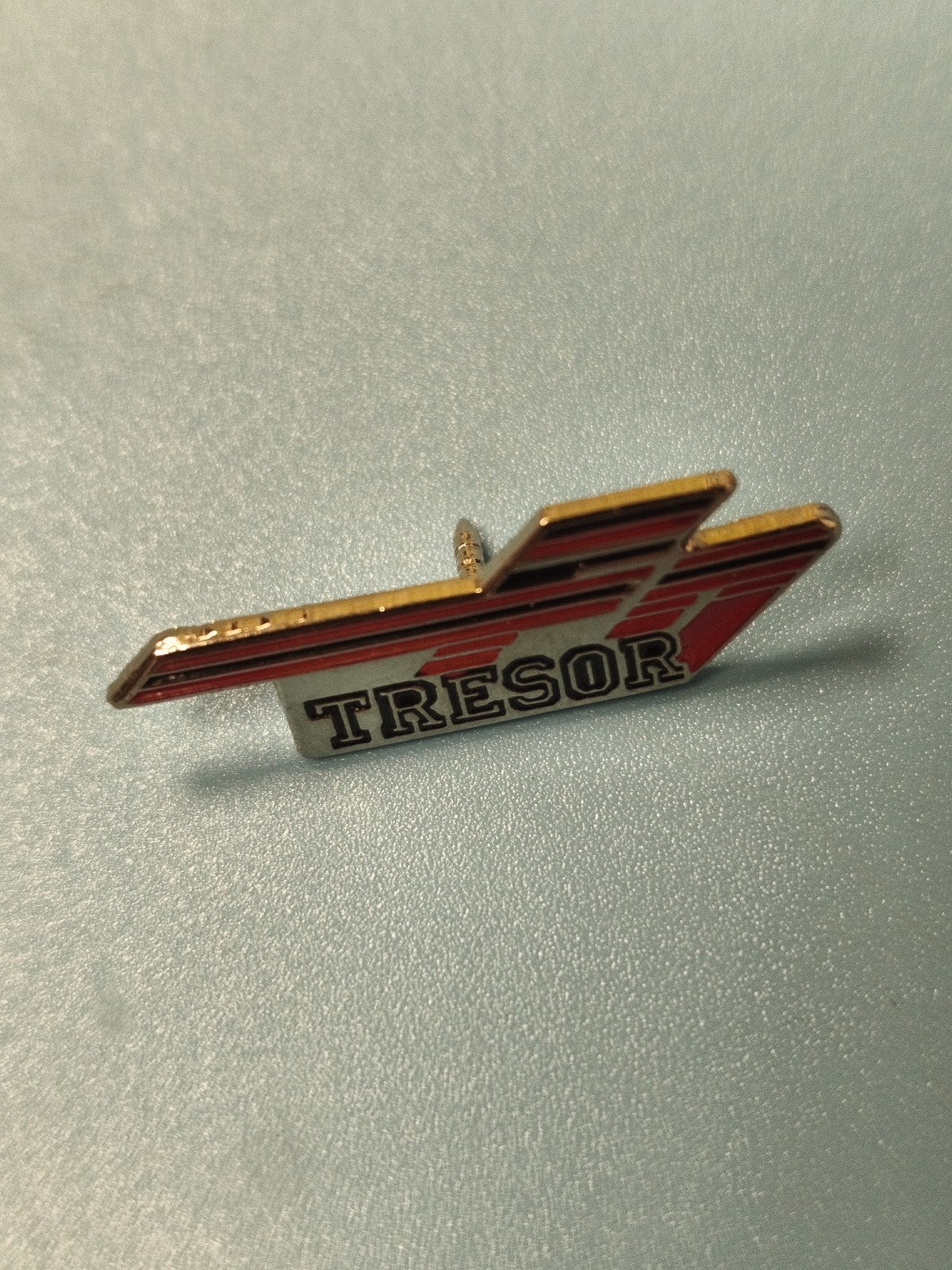 Pin's vintage Trésor, design graphique rouge et noir, collection ancien