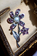 Broche fleur vintage argentée Art Déco strass violets perle centrale