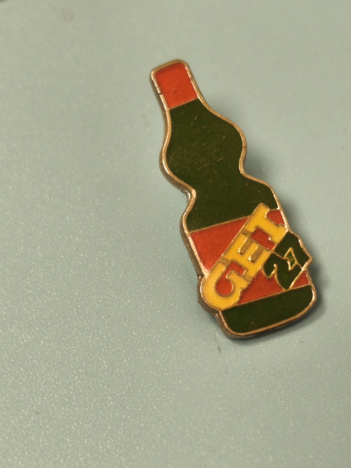Pin's vintage bouteille GET 27 émaillé vert rouge, objet publicitaire rétro