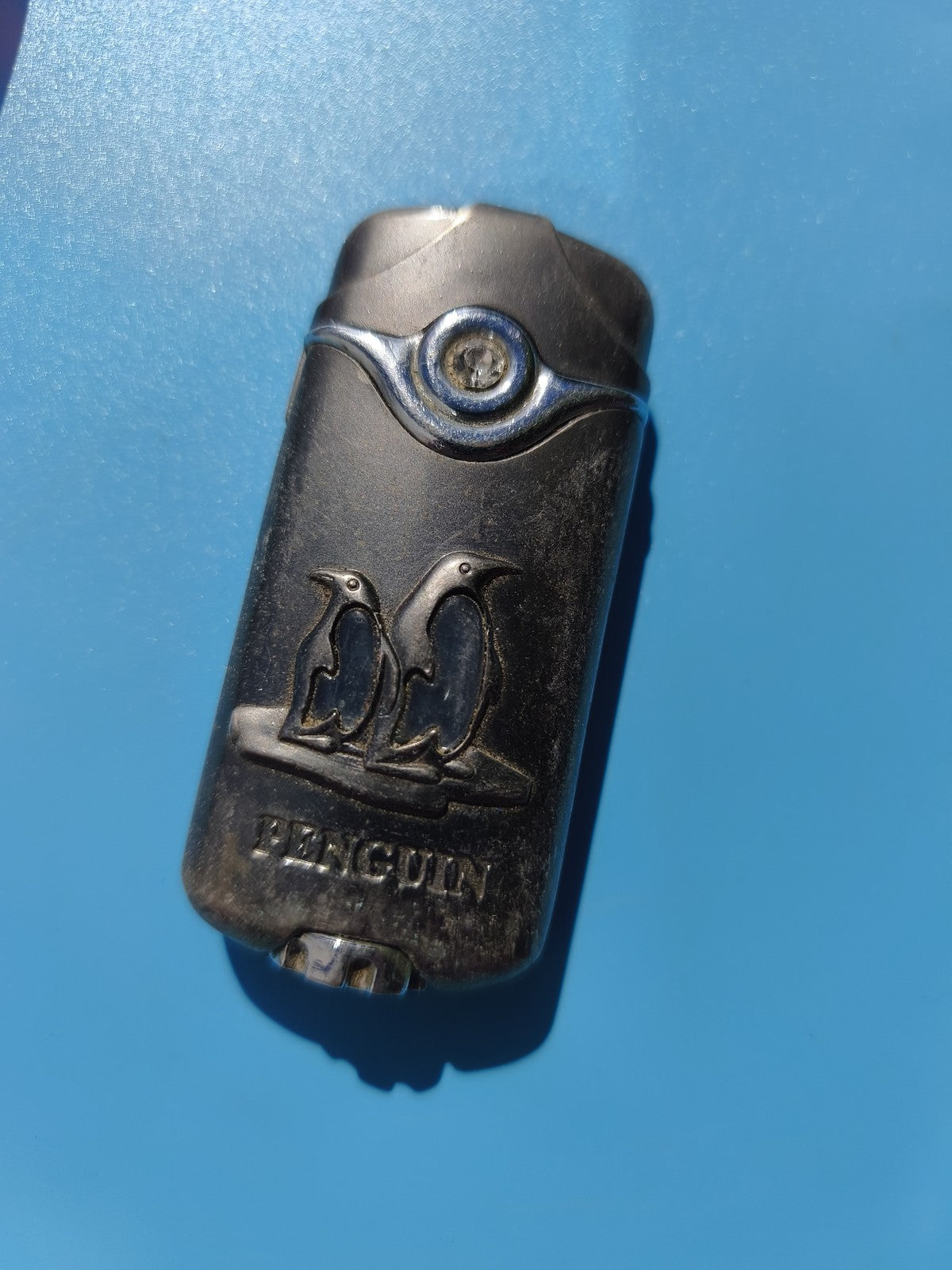 Ancien briquet publicitaire Penguin, motif pingouins, métal, à restaurer