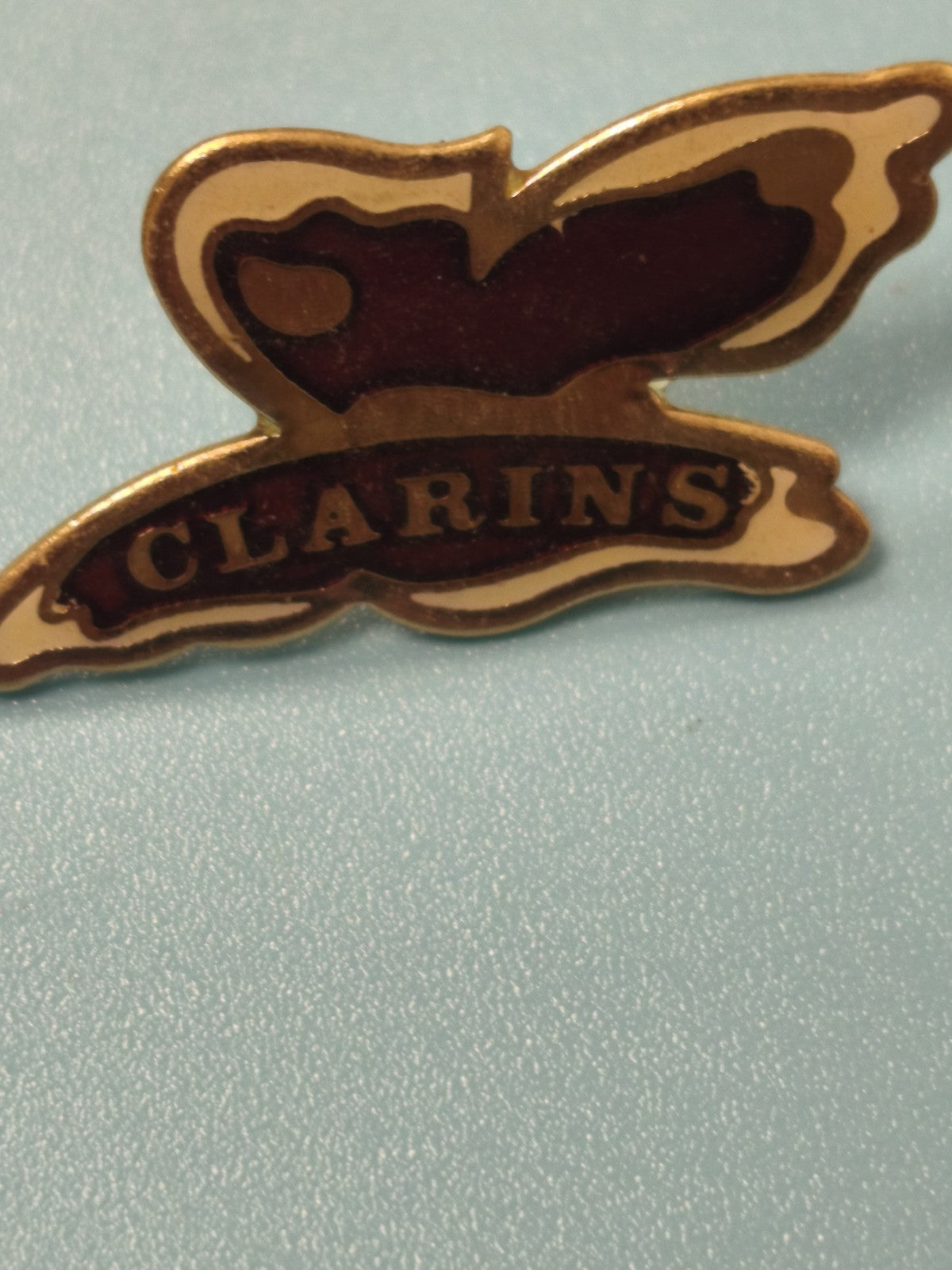Vintage pin's Clarins logo doré rouge, badge ancien collection publicité