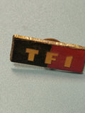 Vintage pin's TF1 ancien, rectangulaire, couleurs noir rouge jaune, collection