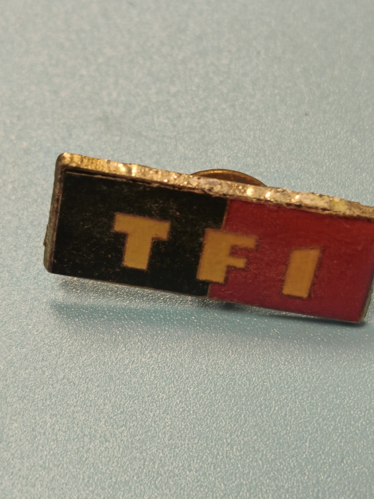 Vintage pin's TF1 ancien, rectangulaire, couleurs noir rouge jaune, collection