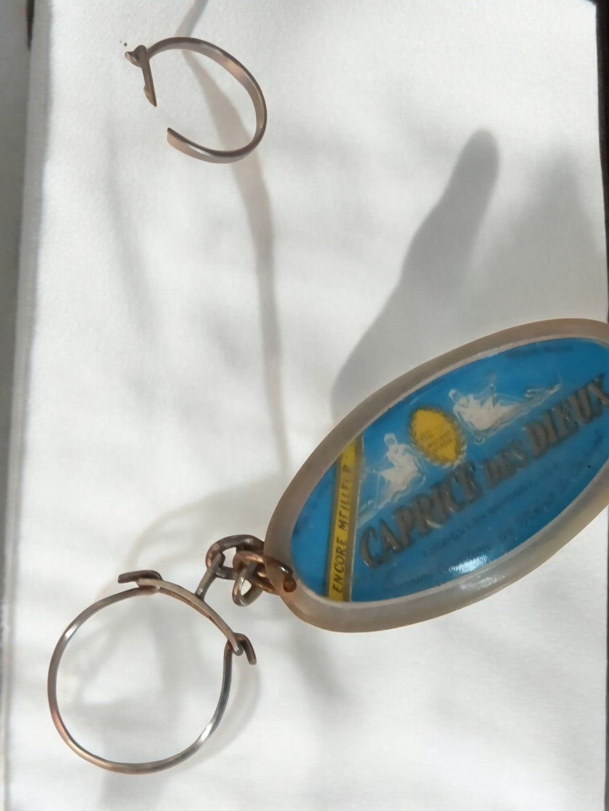 Porte-clés ancien Caprice des Dieux vintage rétro publicitaire ovale bleu
