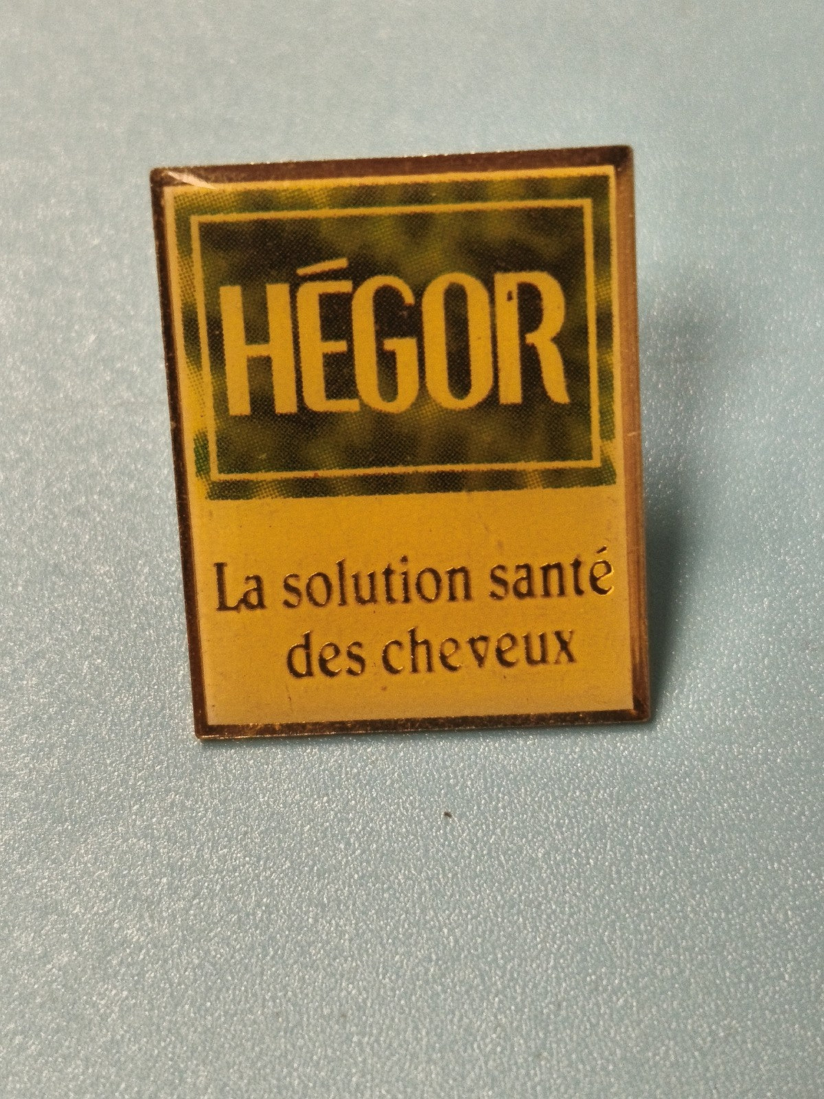 Vintage pin's Hégor publicité santé cheveux carré jaune ancien (Ref 19)