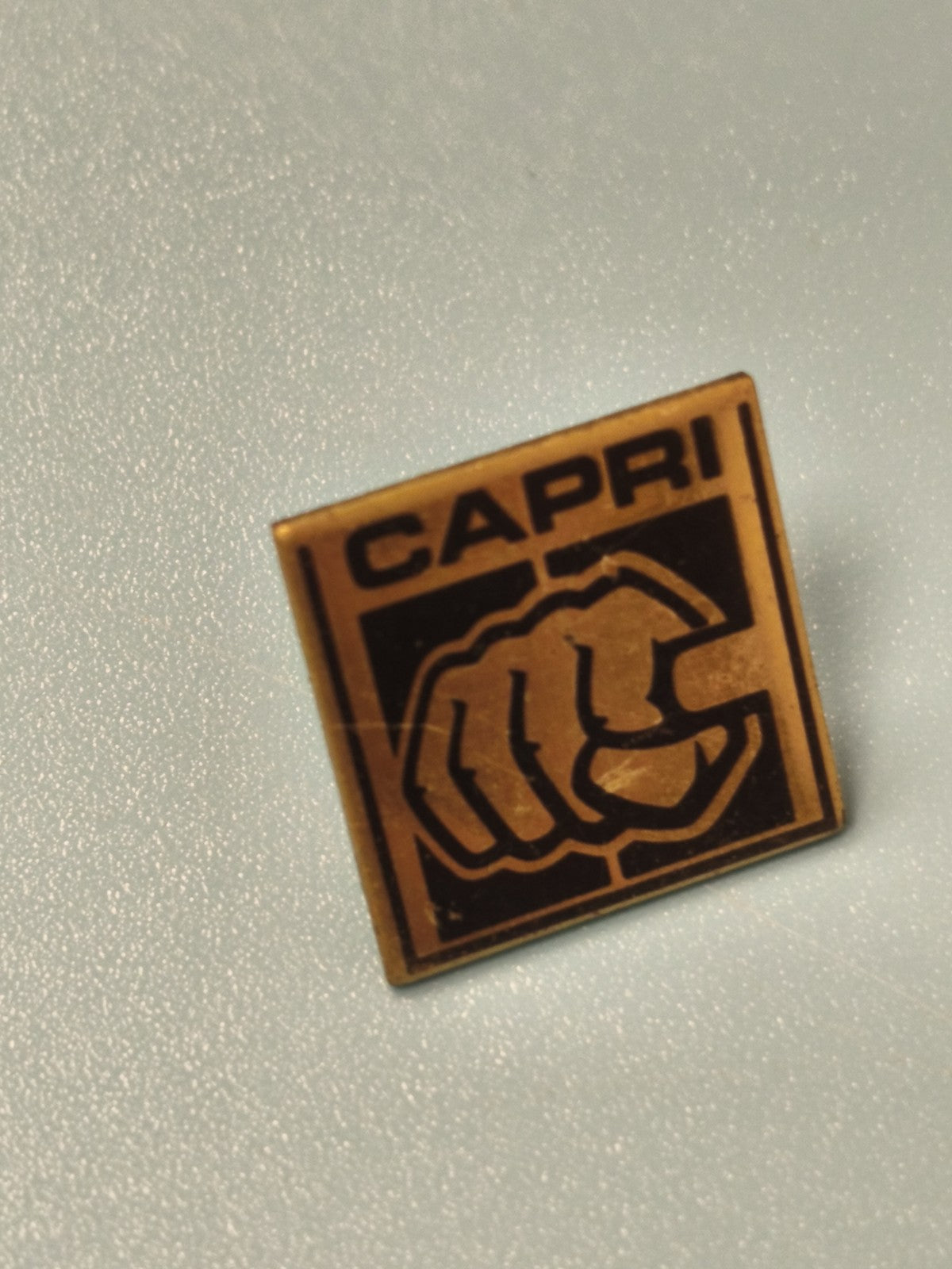 Vintage pin's CAPRI carré logo poing noir doré collection rétro (Ref 12)